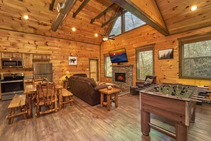Ein gemütliches Holzhaus-Interieur mit Küche, Wohnzimmer und einem Kicker.