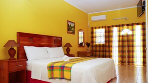 A hotel room with a large bed, two bedside tables with lamps, a window with curtains, and a painting on the wall.