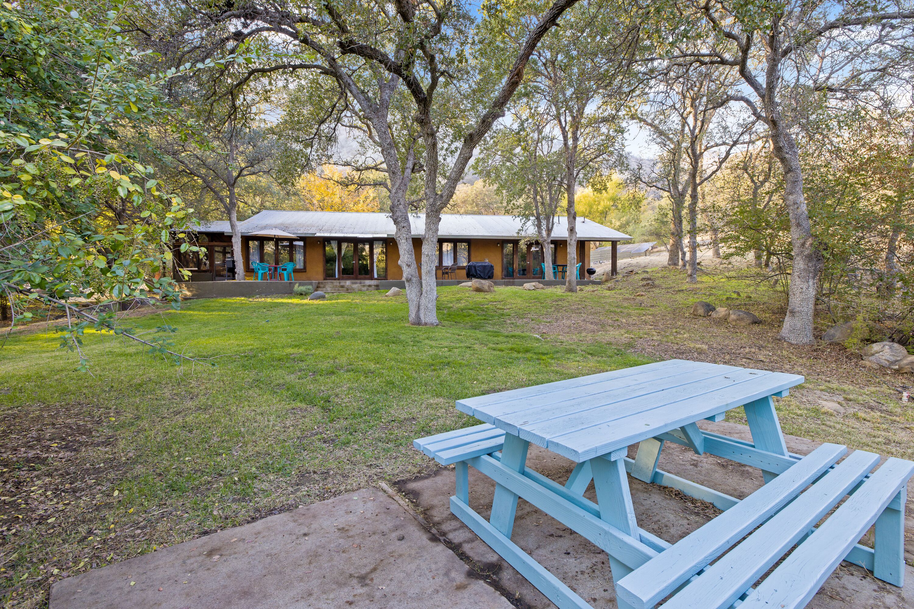 A picnic table in a park with a building in the background.