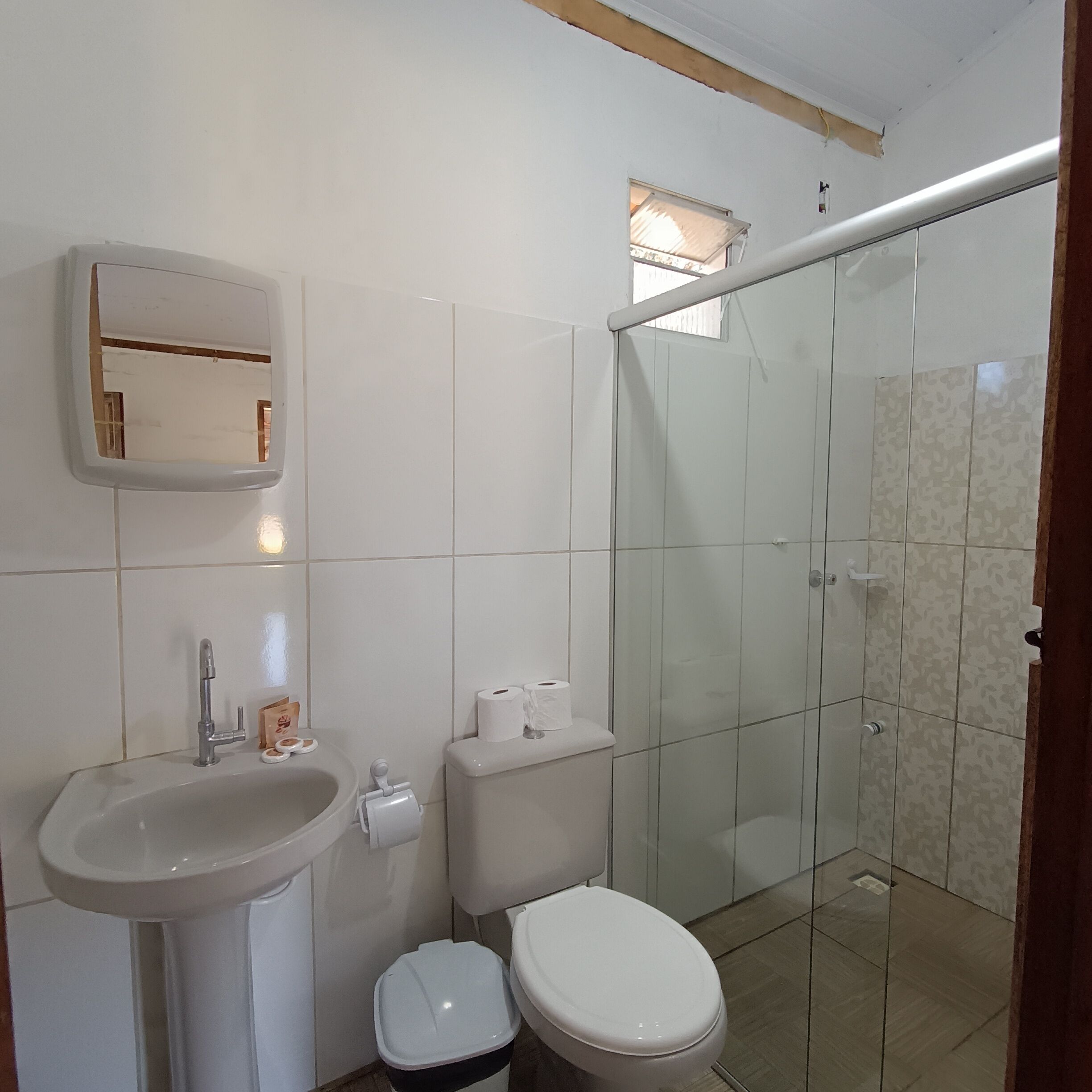 Un bagno con lavandino, WC e cabina doccia in vetro.