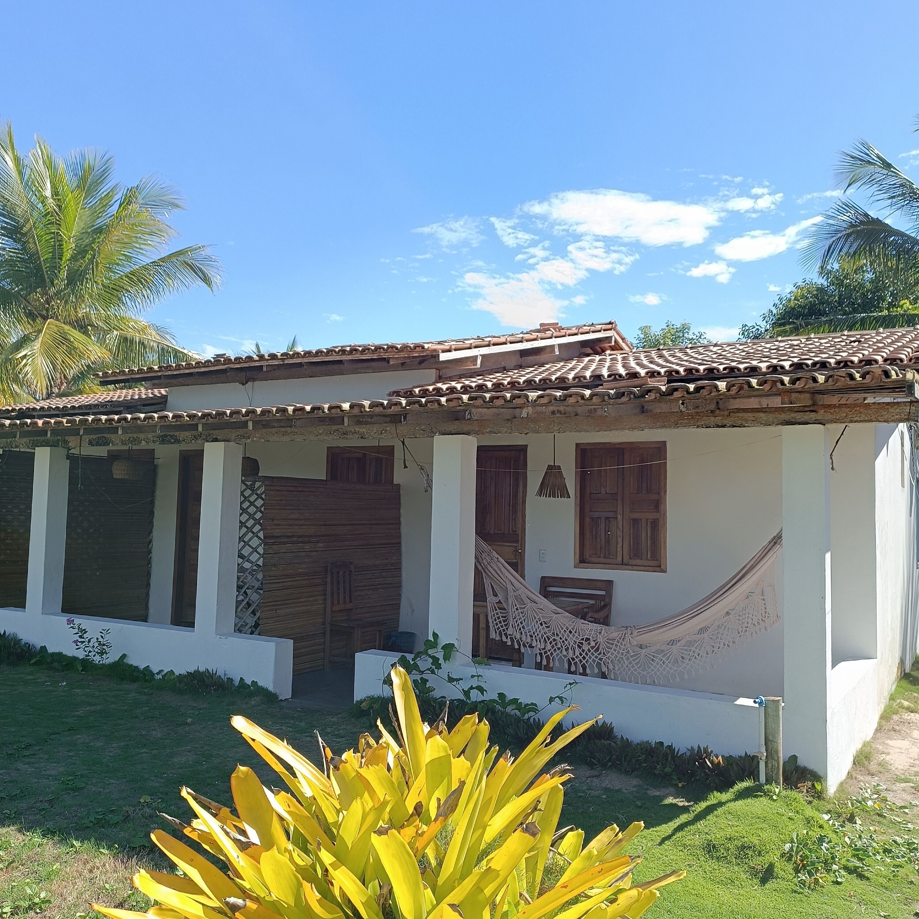A single-story house with a tiled roof, wooden doors, and windows.