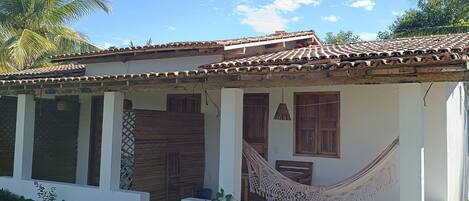 Una casa de un piso con techo de tejas, puertas y ventanas de madera.