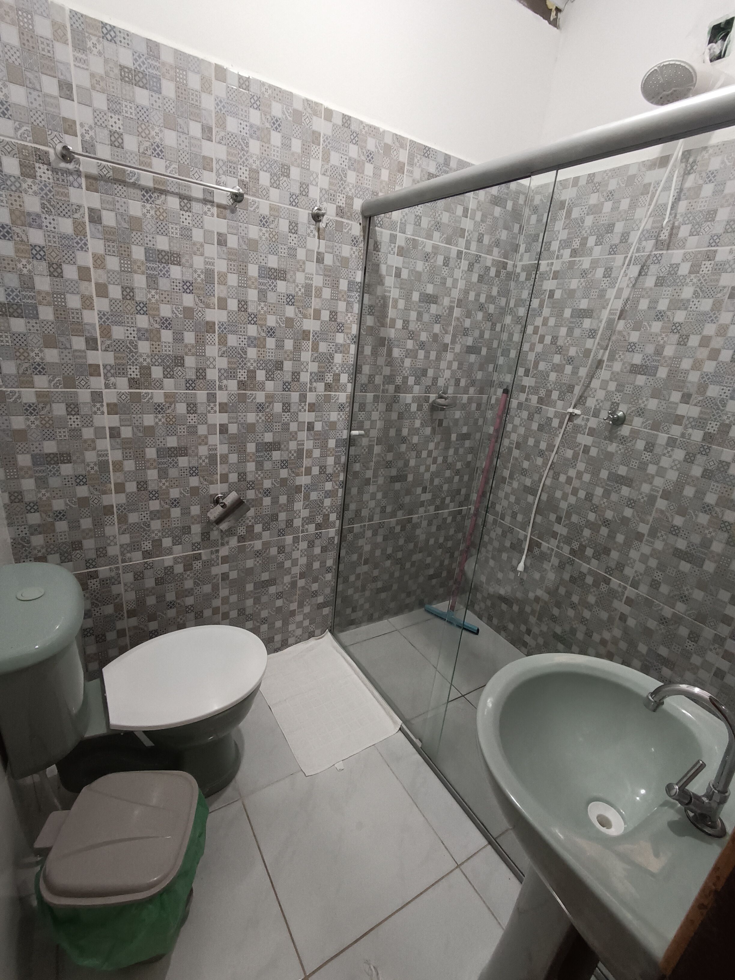 A bathroom with a toilet, sink, and shower area.