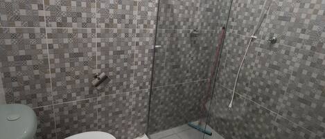 A bathroom with a toilet, sink, and shower area.