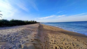 A beach with footprints in the sand and a clear blue sky. - POUSADA PEDRA DO NEGRO (Porto Seguro)