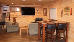 A wooden interior with a TV, a small table, and a couch. - Lakefront Cabin on a Private Lake - only a 0.5 mile from the snowmobile trials! (Crandon)