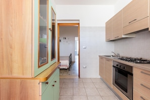 Una cucina con mobili in legno, un fornello e un lavello.
