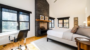 A modern bedroom with a fireplace, large windows, a sofa, and a desk. - Harbert Home With Private Pool & Hot Tub! Close To Beach!! (Harbert)
