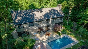 A modern house with a large deck, a swimming pool, and lush surrounding vegetation. - Harbert Home With Private Pool & Hot Tub! Close To Beach!! (Harbert)