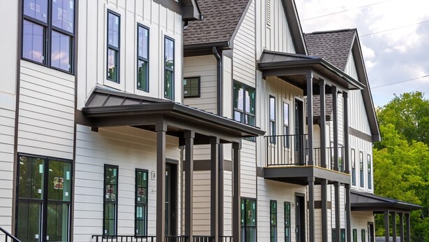 A multi-story residential building with a symmetrical facade, large windows, and a prominent balcony on the second floor. - The Lischey House-East Nashville (Nashville)