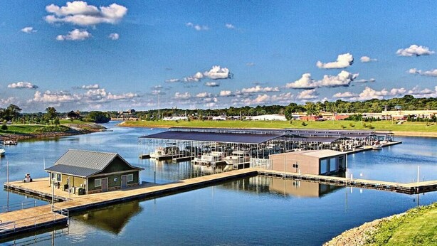 Un puerto deportivo con muelles, una zona cubierta y un barco.