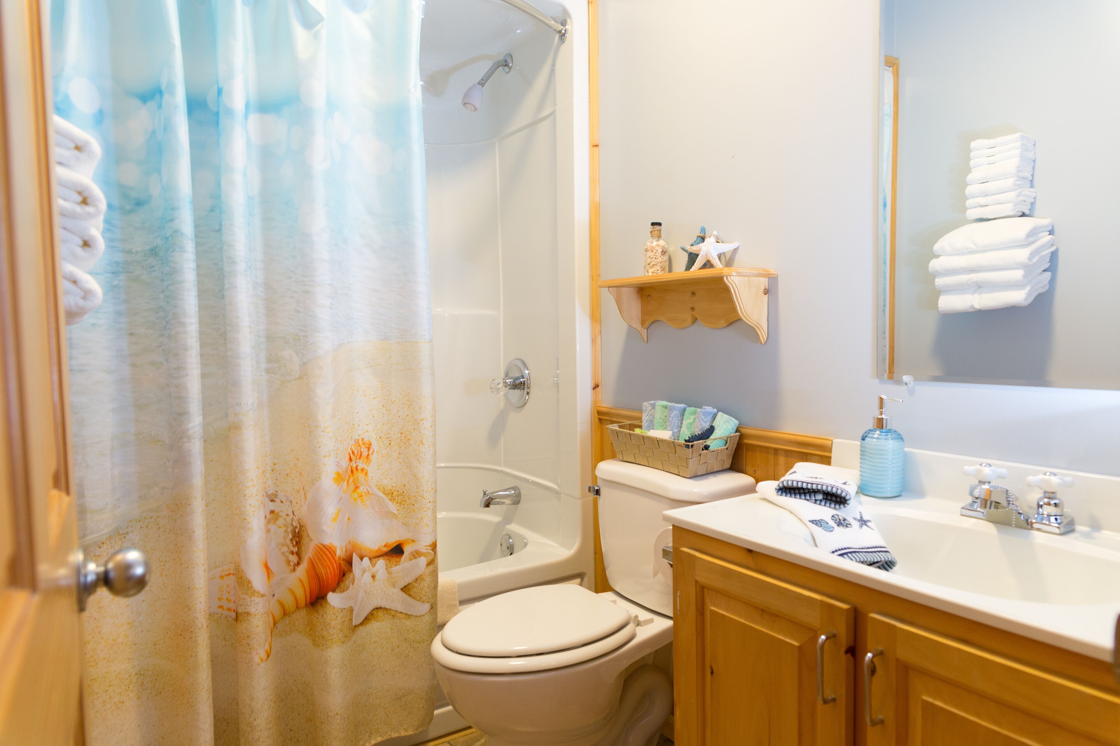 Un baño con ducha, inodoro, lavabo y toallero.