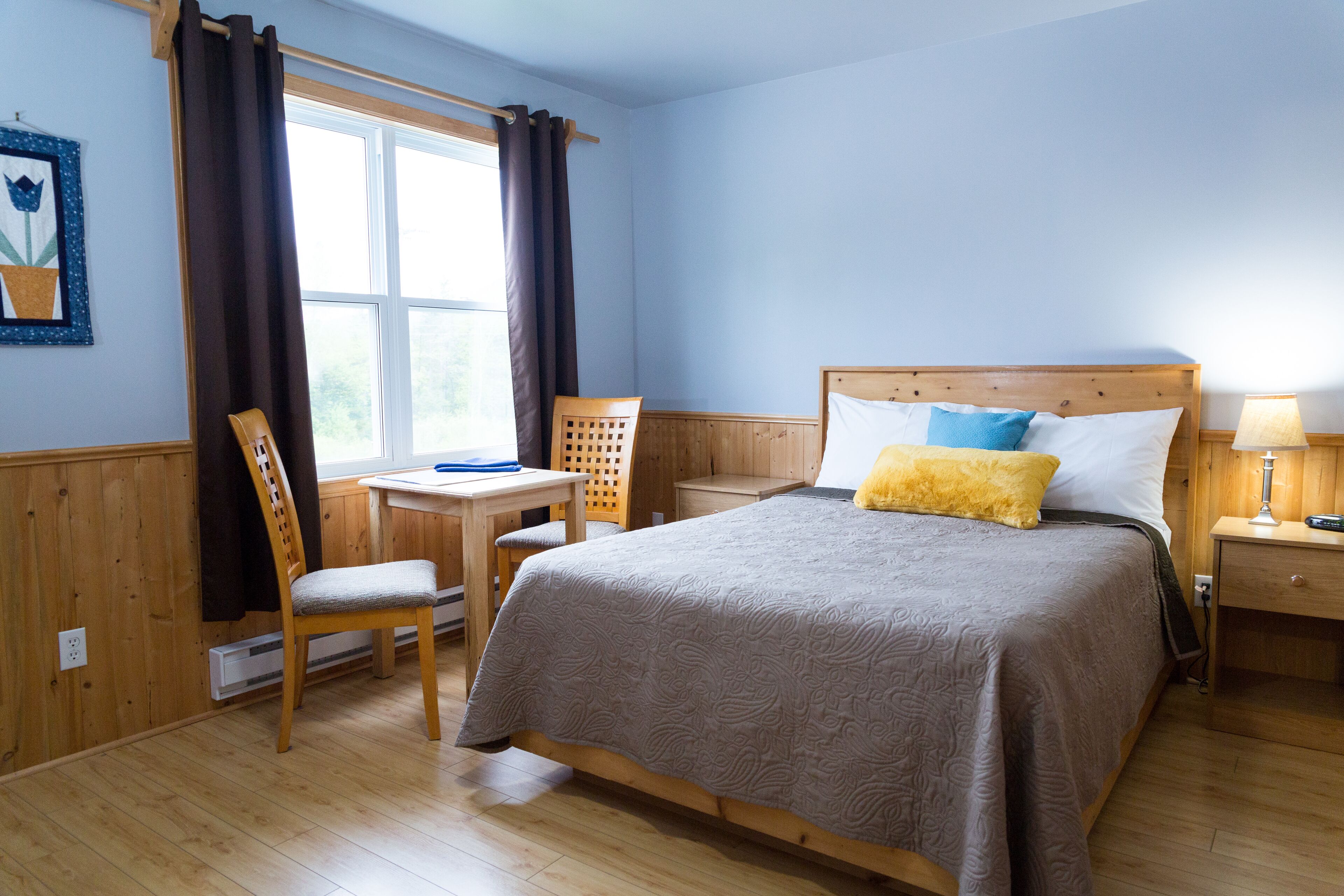 A bedroom with a wooden bed, a desk, and a chair.