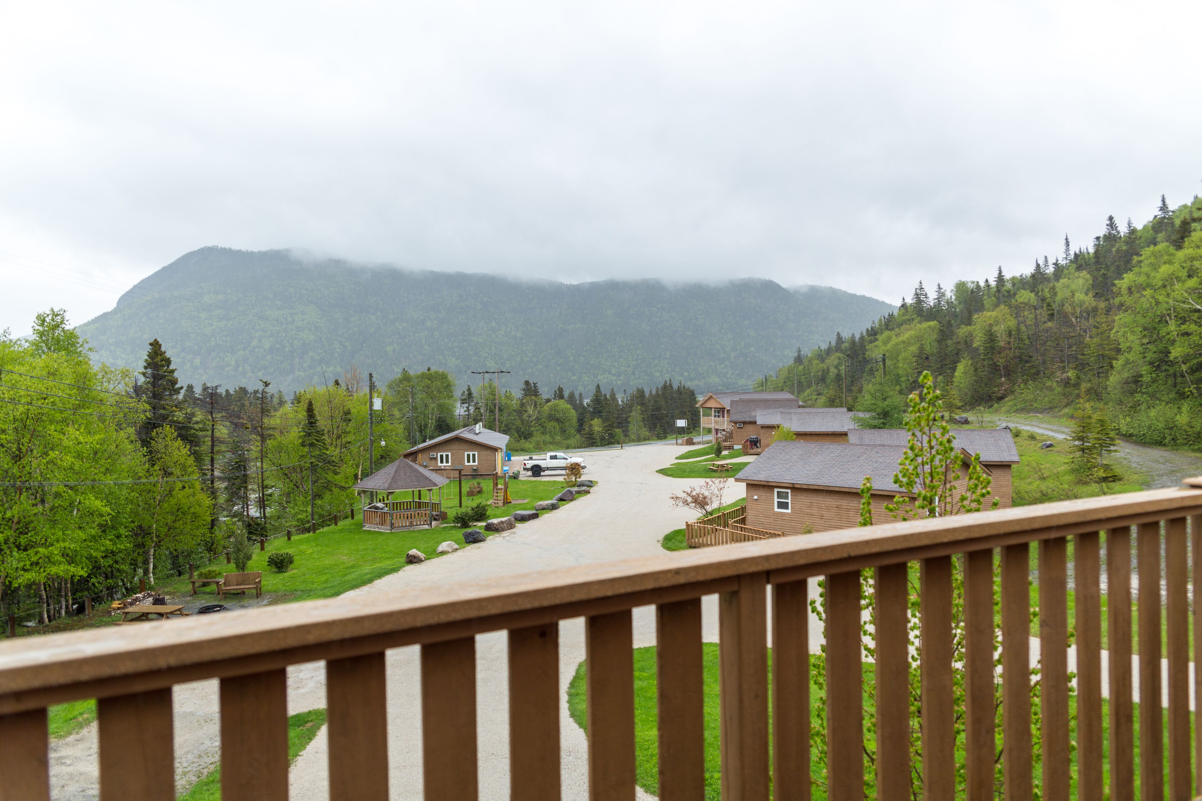 A residential area with houses, a wooden deck, and a mountain in the background.