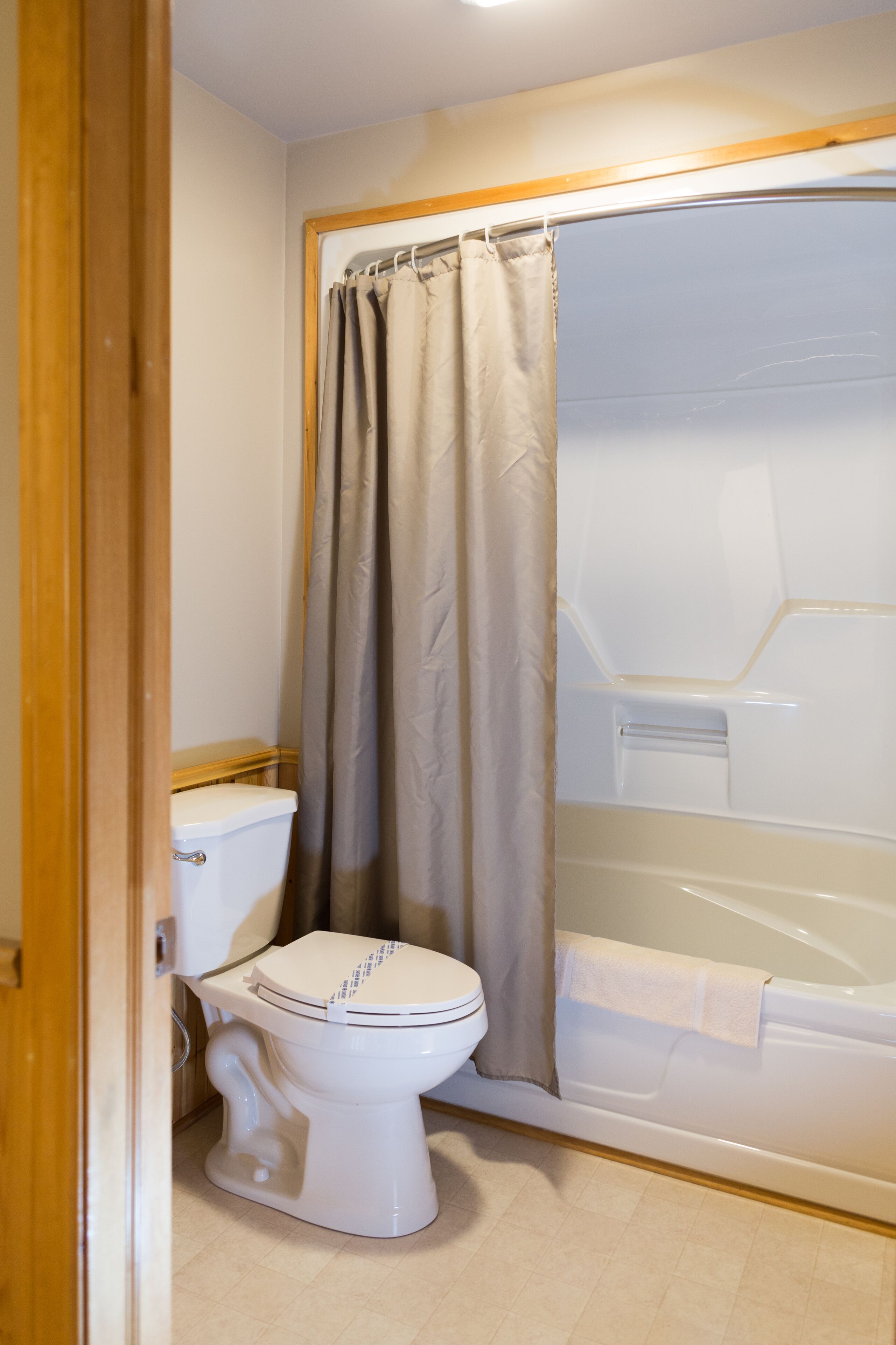 Un bagno con il water, una vasca e una tenda da doccia.