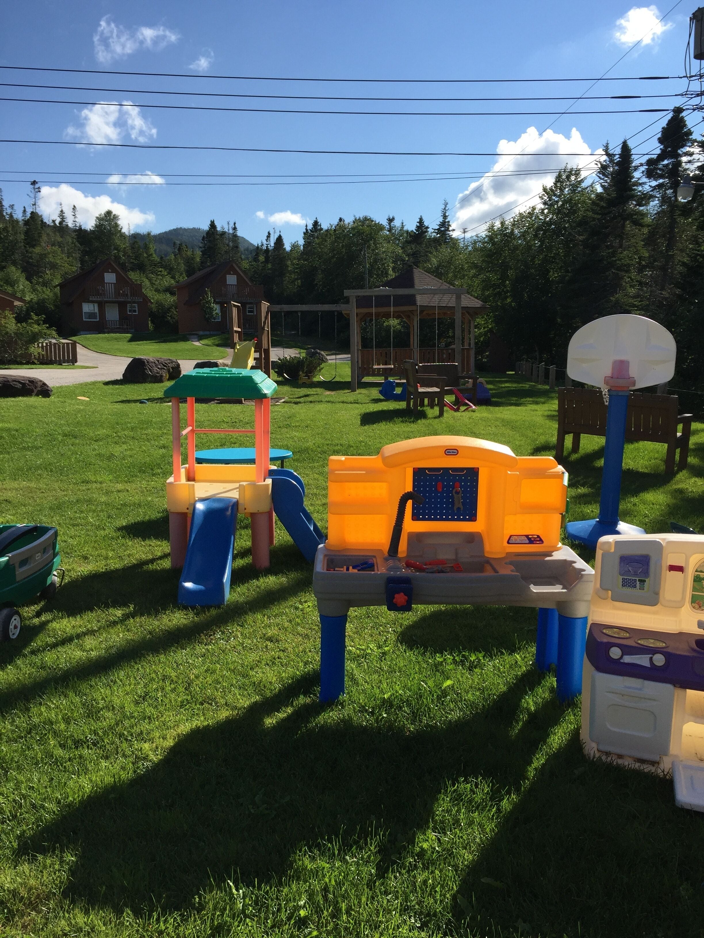A playground with various play structures including a slide, climbing frame, and a basketball hoop.