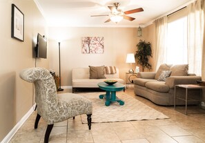 Relax in this inviting living room with a comfortable sofa set, armchair, and round table.