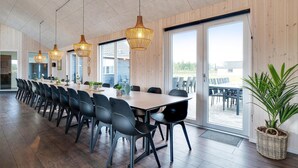 A spacious dining area with a long table, black chairs, and hanging wicker chandeliers. - Nice home in Nørre Nebel with sauna (Nørre Nebel)