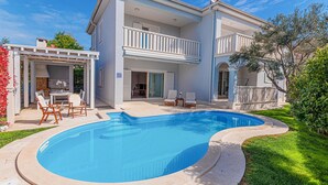A two-story house with a swimming pool, outdoor seating, and a covered patio area. - Luxurious home in Vodice (Vodice)