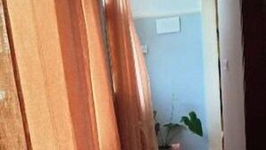 Un corridoio con pavimento piastrellato e pannelli di legno alle pareti.