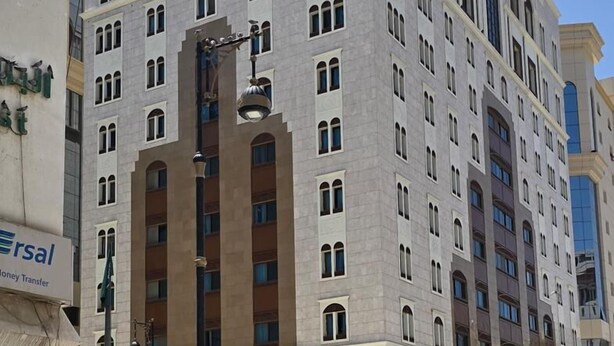 A multi-story hotel with a symmetrical facade, large windows, and a central entrance with a light fixture. - Hotel  Karam Al Madina (Madinah)