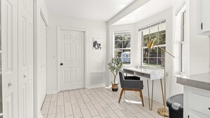A modern kitchen with white cabinetry, a marble countertop, and a window with a view of the outside. - Greenway Getaway Near Silver Springs, walking distance to Cross Florida Greenway (Ocala)