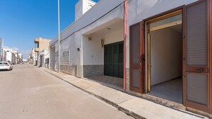 A street view of a building with a large open door and a covered entrance.