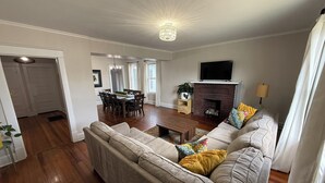Ein Wohnzimmer mit einer Couch, einem Esstisch und einem Kamin.