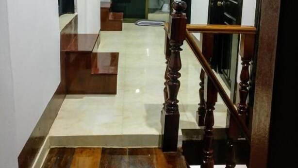 A staircase with wooden steps and a wooden handrail leading to a landing. - Chitlatda Guesthouse (Luang Prabang)
