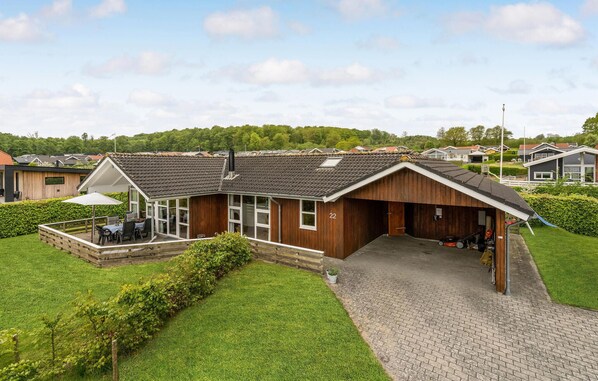 A modern house with a garage, a patio with outdoor furniture, and a well-maintained lawn. - Beautiful home in Sjølund with WiFi (Sjølund)