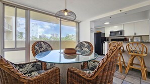 A modern kitchen with white cabinets, a microwave, and a black refrigerator. - Remodeled in 2022, Diamond Head 2 Bedroom Oceanfront condo (Honolulu)