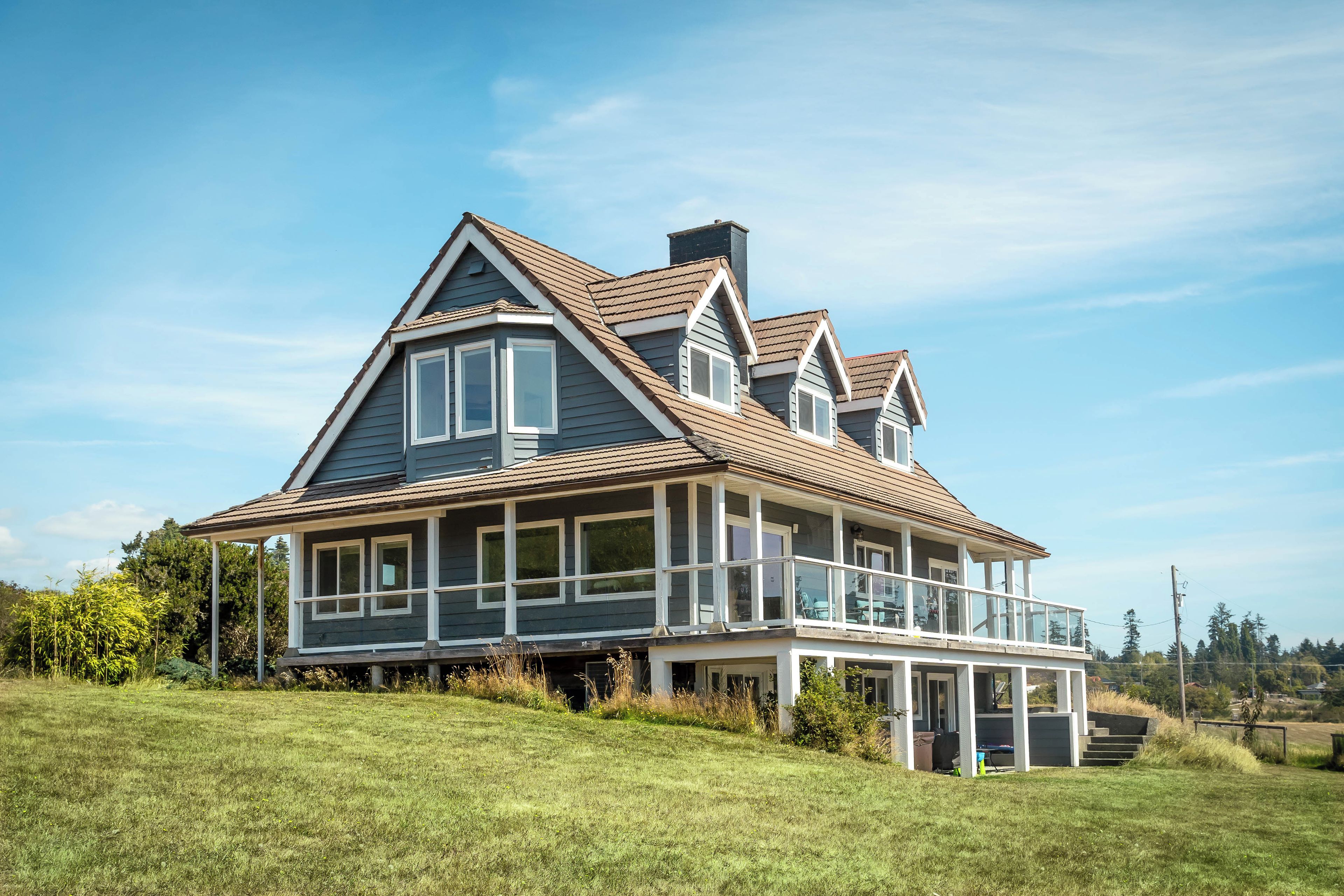 A large two-story house with a wrap-around porch and a covered front deck.