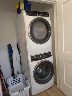 A compact, two-door front-loading washing machine in a laundry room. - Beautiful beachfront Villa on 80 acres of farmland! (Sooke)