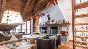 A cozy living room with a fireplace, leather sofas, a coffee table with a map, and wooden beams on the ceiling. - Valartíes (Artíes)