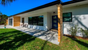 Une maison moderne à deux étages, dotée d’un porche abrité, d’un garage et d’une pelouse bien entretenue.