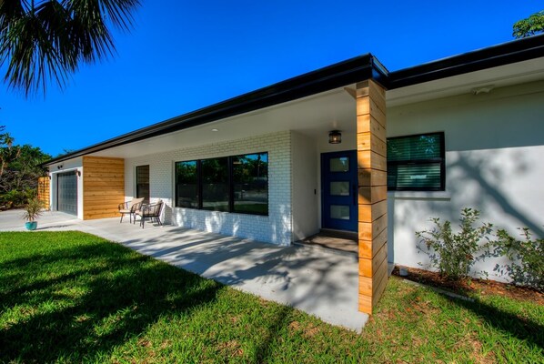 Une maison moderne à deux étages, dotée d’un porche abrité, d’un garage et d’une pelouse bien entretenue.