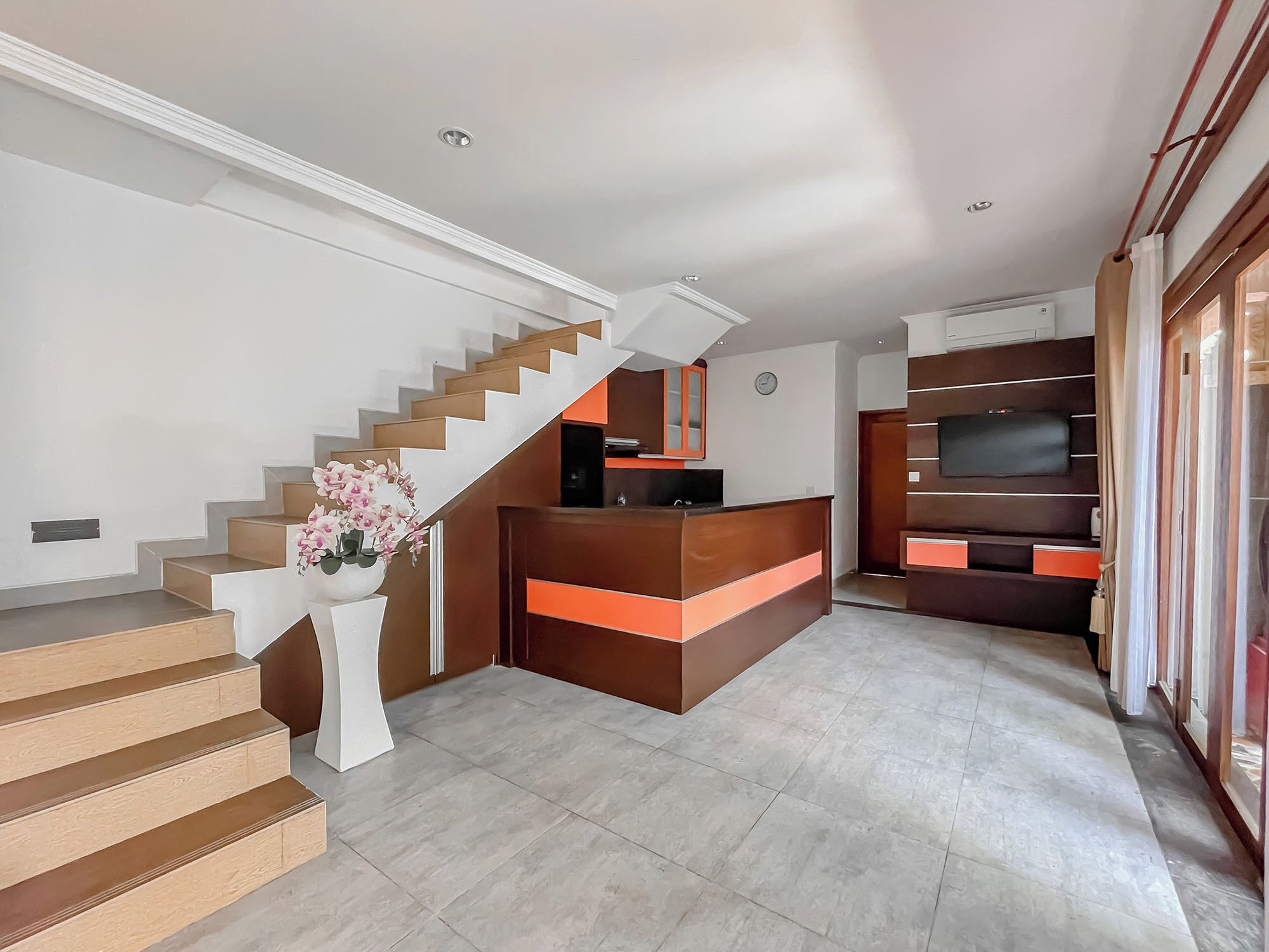 Ein modernes Wohnzimmer mit Treppe, einem Holzbüro und einer integrierten Unterhaltungseinheit.