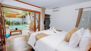 Habitación de hotel con una cama grande, piso de madera, vista a la piscina, televisor y ventilador de techo.