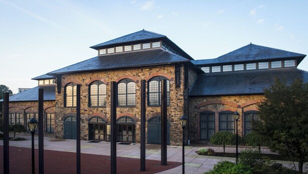 A historic building with a stone facade, large arched windows, and a flat roof. - New Spacious single w/ parking.  Bikes, XBOX, (Phoenixville)
