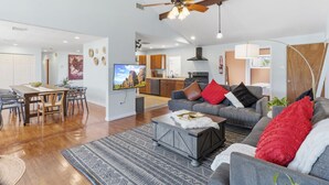 A spacious living room with a dining area, a kitchen in the background, and a ceiling fan. - 5BD/3BA Ranch with Vaulted Ceilings in Heart of AC (Atlantic City)