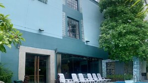 Um edifício com uma placa que diz "Tapa Place" e uma piscina com espreguiçadeiras.