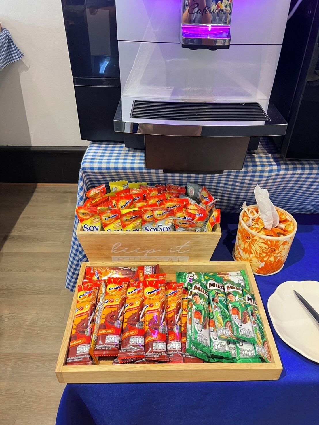 A buffet table with various food items, including packaged snacks and a cup with a napkin.