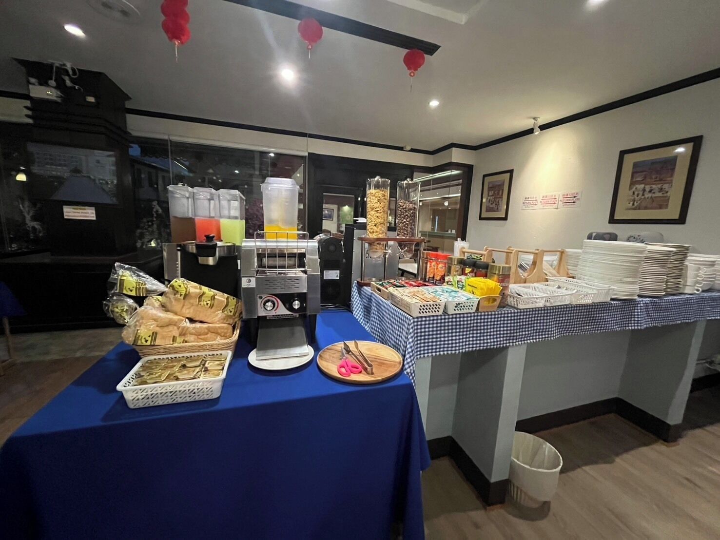 A buffet setup with a coffee machine, food containers, and a variety of snacks.