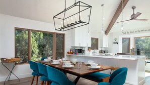 Eine moderne Küche mit weißen Schränken, einem Holzespeisetisch und blauen Stühlen.