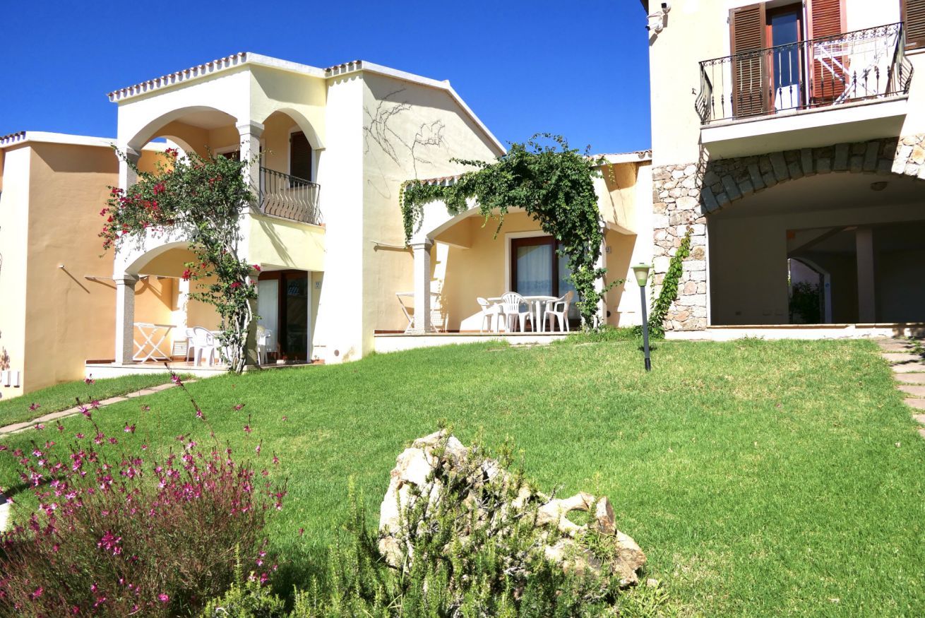 A building with a courtyard, outdoor seating, and a stone wall.