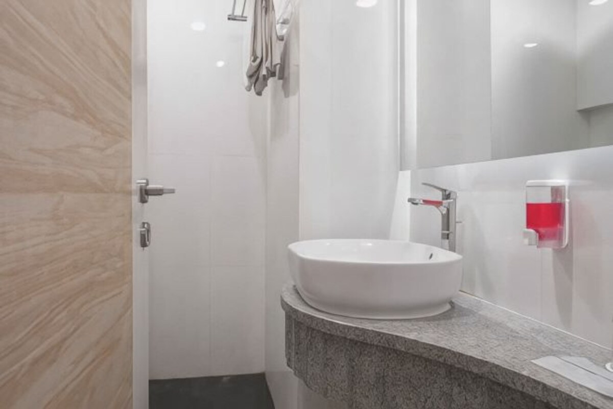 A bathroom with a white sink, a mirror, and a towel rack.