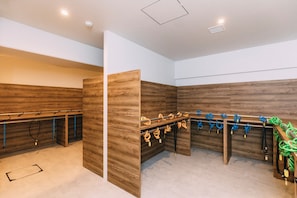 A room with wooden panel walls, a futsal court, and a rack with various sports equipment. - WeBase KYOTO - Hostel (Kyoto)