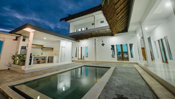 Ein modernes Haus mit Swimmingpool, einer überdachten Terrasse und einem großzügigen, offenen Bereich.