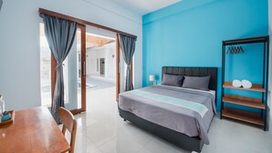 Ein Hotelzimmer mit Bett, Holztisch, Stuhl, Nachttisch und Kleiderschrank.