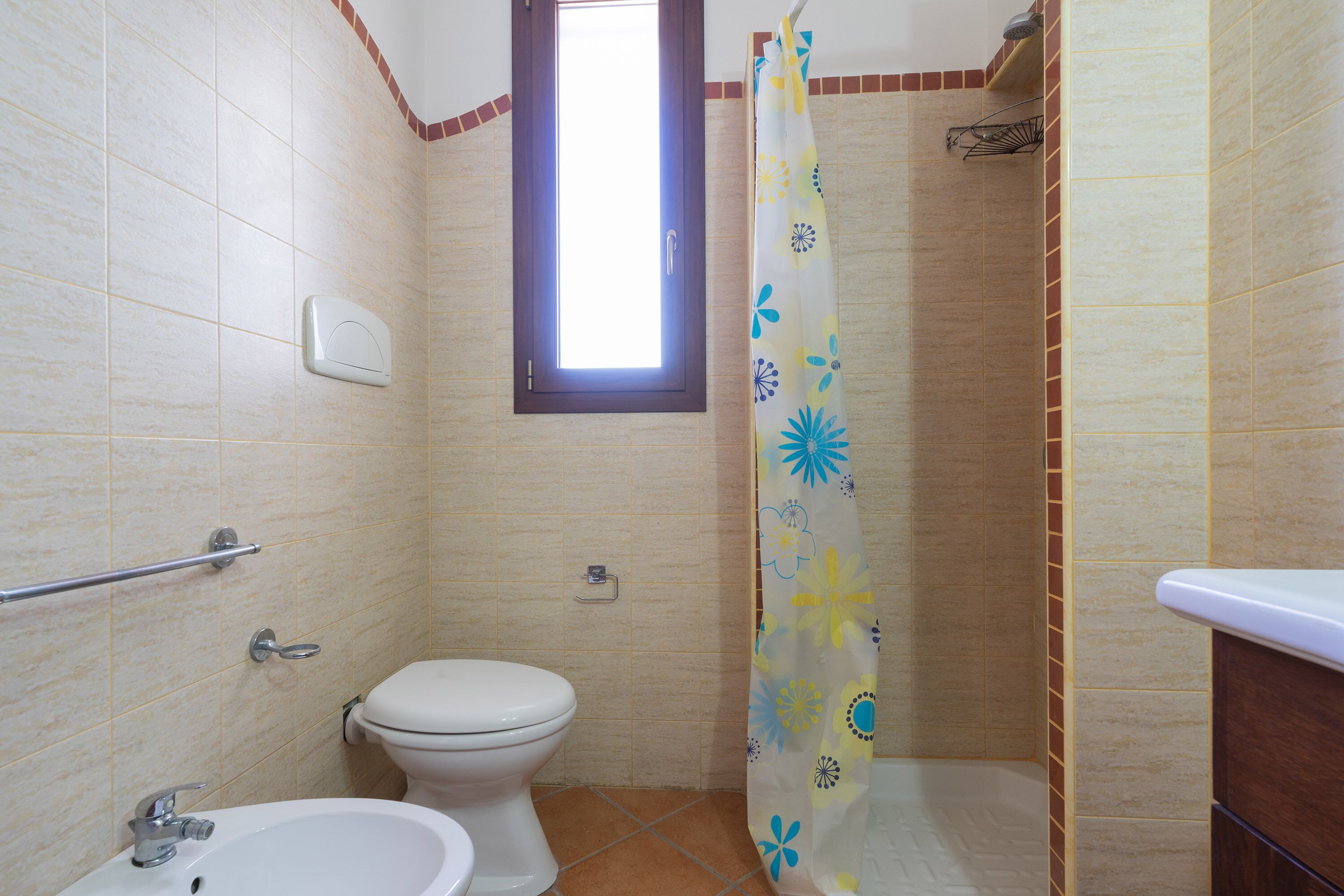 Une salle de bain comprenant des toilettes, un lavabo et un espace douche.